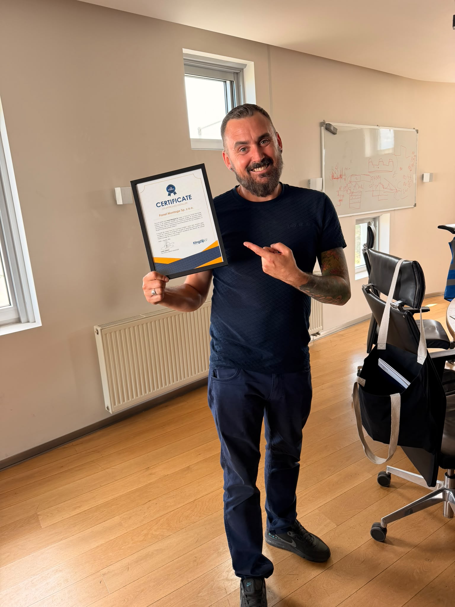 Maciej Stępień holding the KingZip SF certificate for Panel Montage